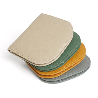 Stack of four pebbled cowhide leather bifold wallets in ivory, green, yellow and grey