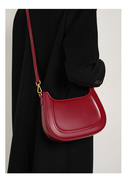 Wine red leather shoulder bag worn crossbody on model