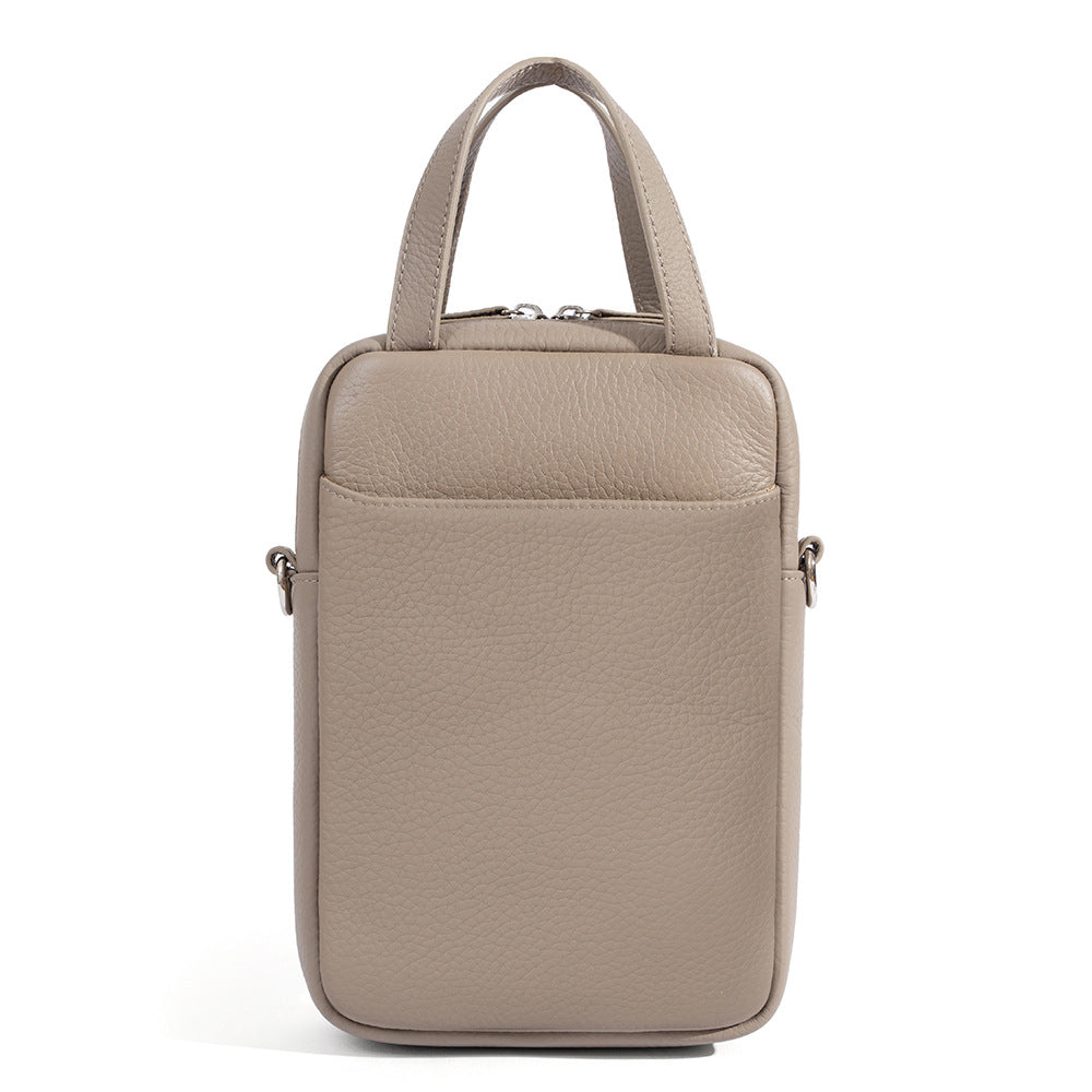 Front detail of light gray pebbled leather phone bag highlighting front slip pocket and topstitching