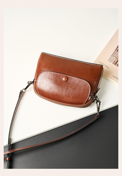 Close-up of caramel leather crossbody flap and contrast stitching