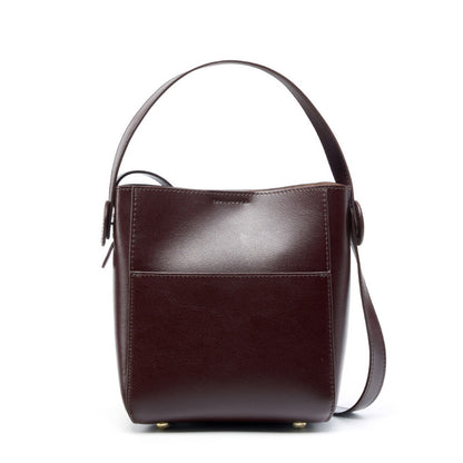 Coffee brown leather bucket bag with vertical silhouette and visible topstitching