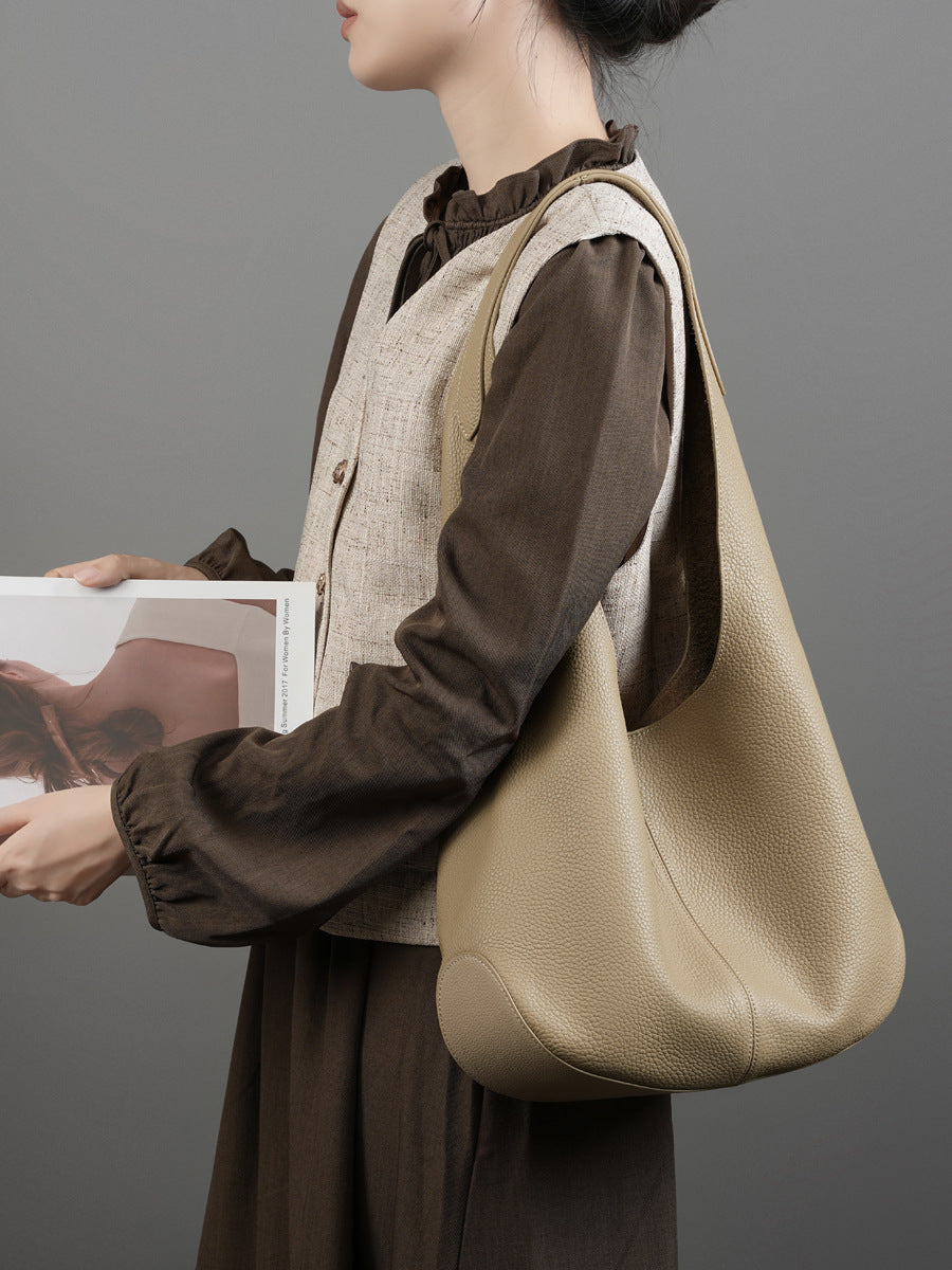 Beige bucket tote worn over the shoulder with casual outfit