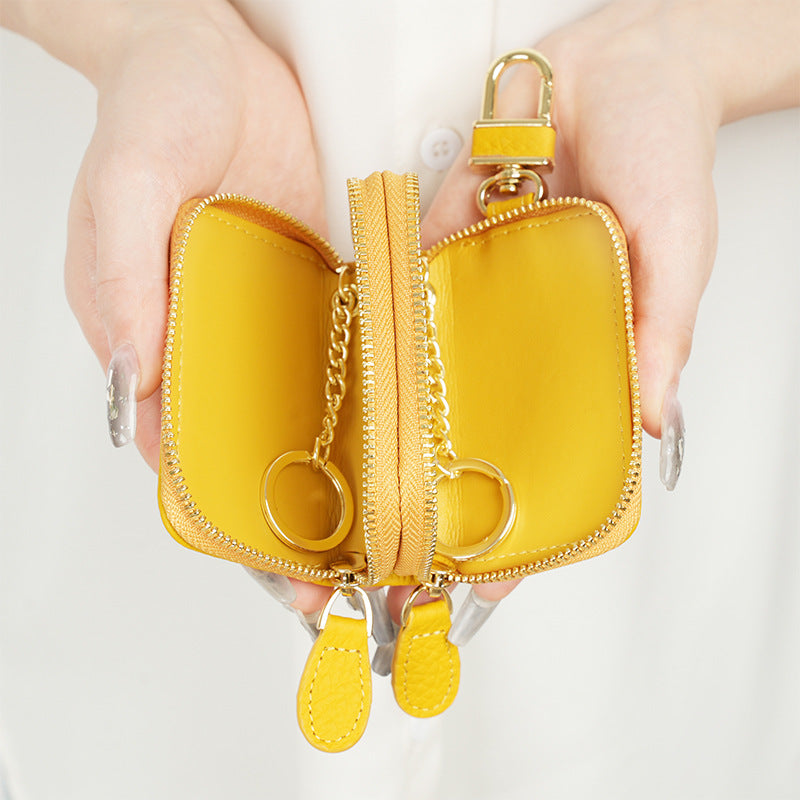 Yellow cowhide leather key case pouch opened to show interior chain link and dual compartments