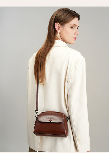 Side angle of model carrying brown leather mini crossbody
