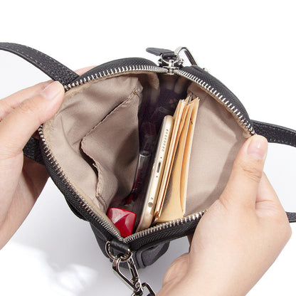 Top-down view of Mara crossbody bag interior with phone, cards and pouch