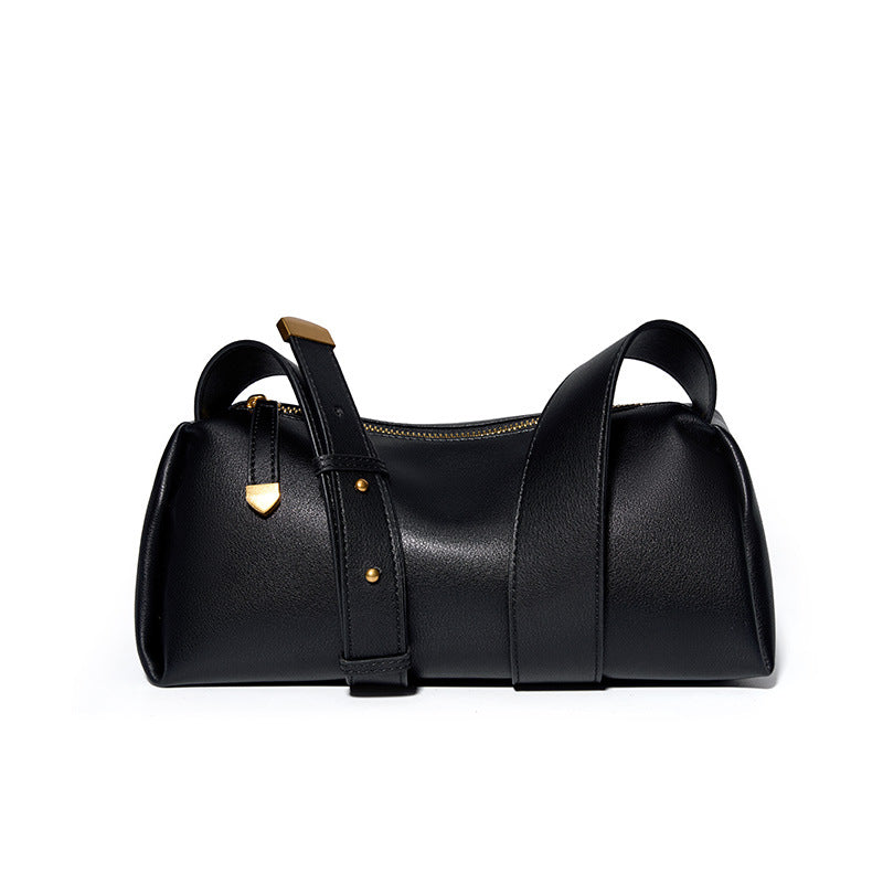 Black cowhide pillow crossbody bag with wide adjustable strap on white background