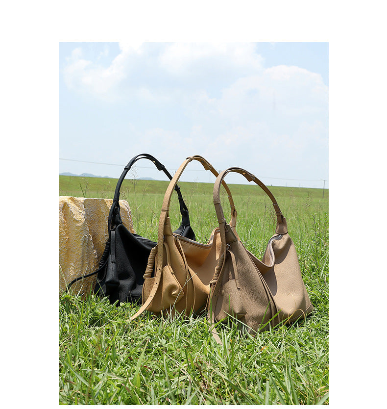 Group shot of three leather hobo bags in different colors on grass