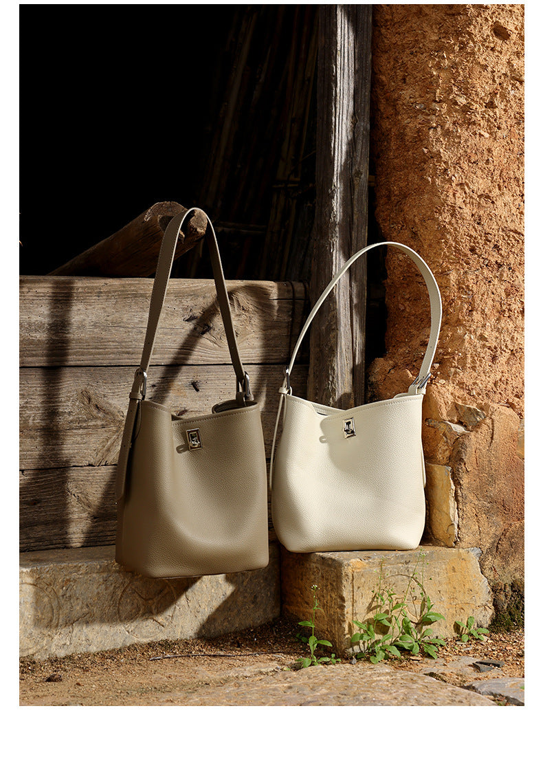 Close-up of the metal lock clasp detail on a khaki leather bucket bag