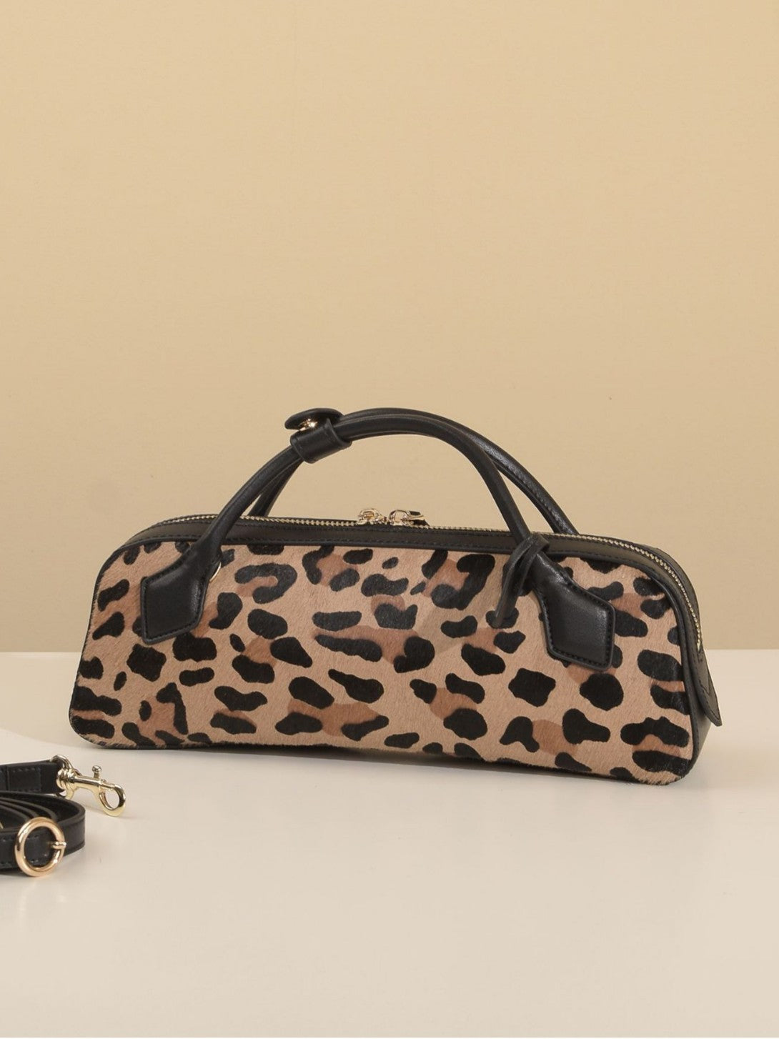 Angled front view of structured brown leopard shoulder bag