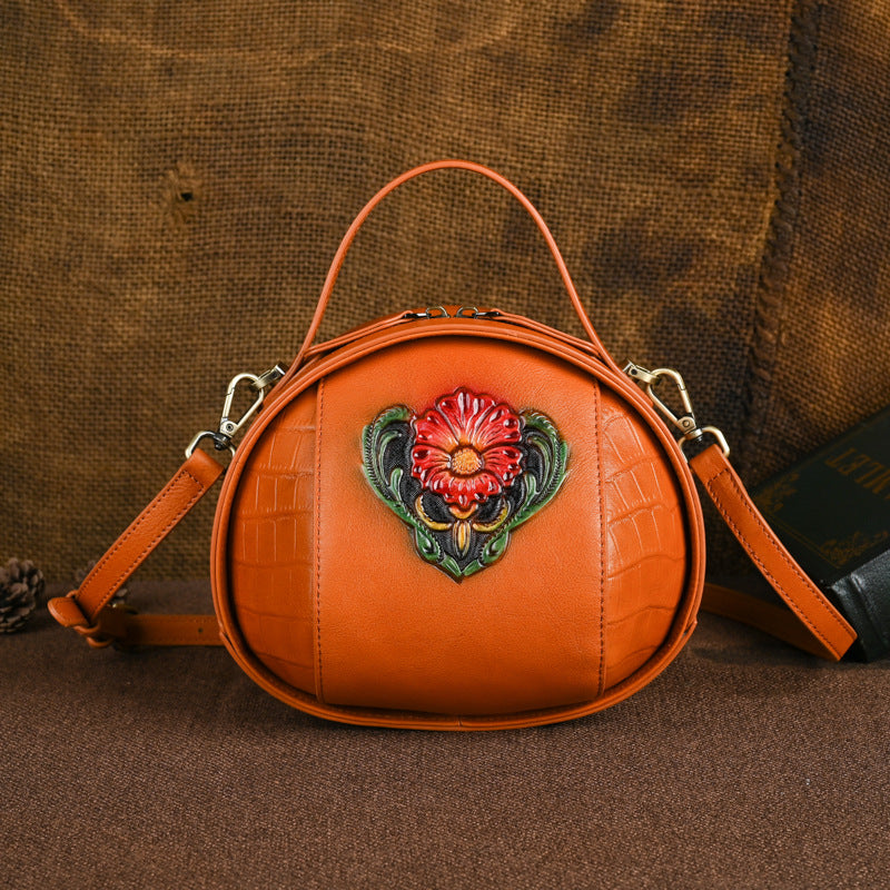 Vintage brown round cowhide crossbody bag with raised floral artwork