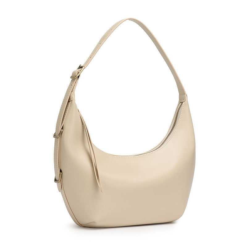 Beige crescent leather bag on white background