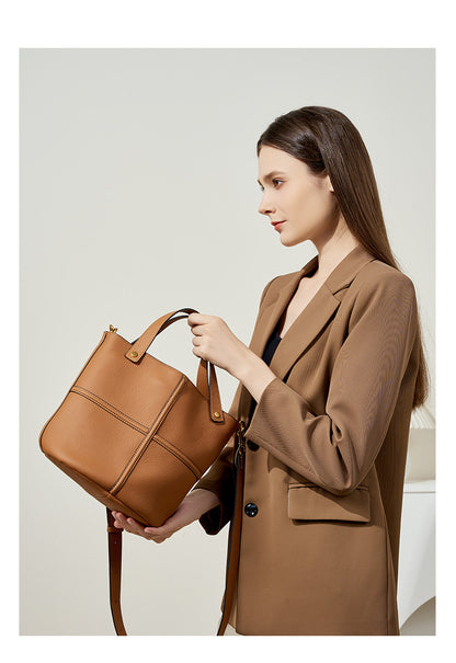 Model showing the side profile of the brown bucket bag