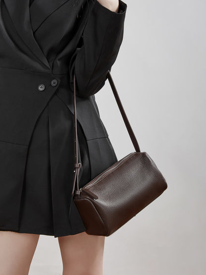 Model wearing the coffee barrel bag crossbody with a black blazer