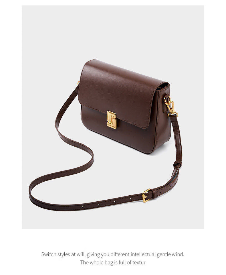 Brown cowhide crossbody bag with adjustable crossbody strap laid out flat