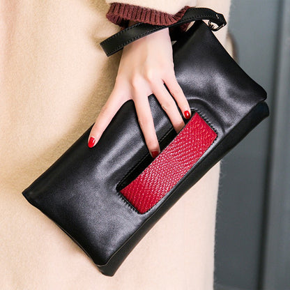 Black leather clutch shown diagonally with red accent and attached strap