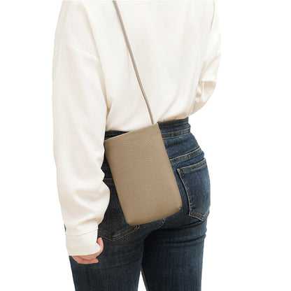 Beige leather crossbody phone bag styled with denim outfit on model