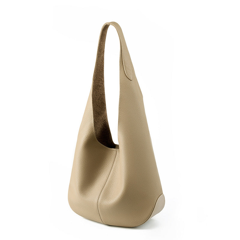 Beige cowhide leather bucket tote bag on white background