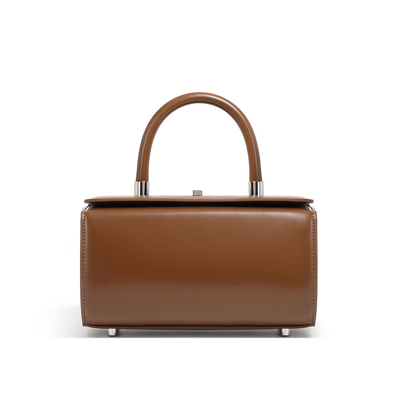 Coffee brown cowhide leather box handbag with rounded top handle on white background
