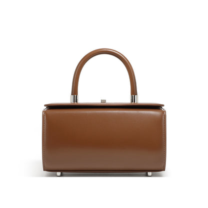 Coffee brown cowhide leather box handbag with rounded top handle on white background