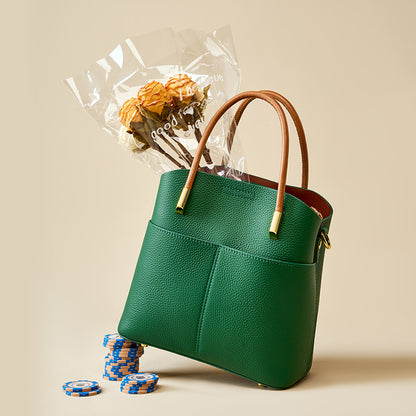 Green cowhide leather bucket bag styled with dried flowers and stacked poker chips