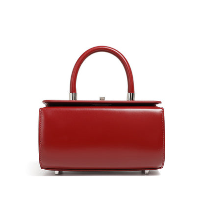 Red cowhide leather box handbag with rounded top handle on white background