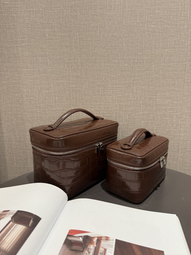 Two chocolate cowhide pouches showing their top handles