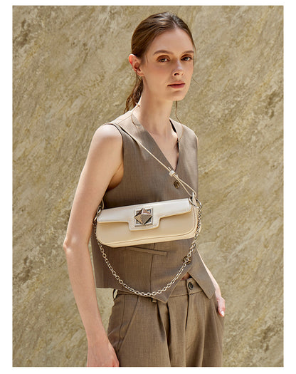Off-white leather baguette shoulder bag with geometric hardware held by a model