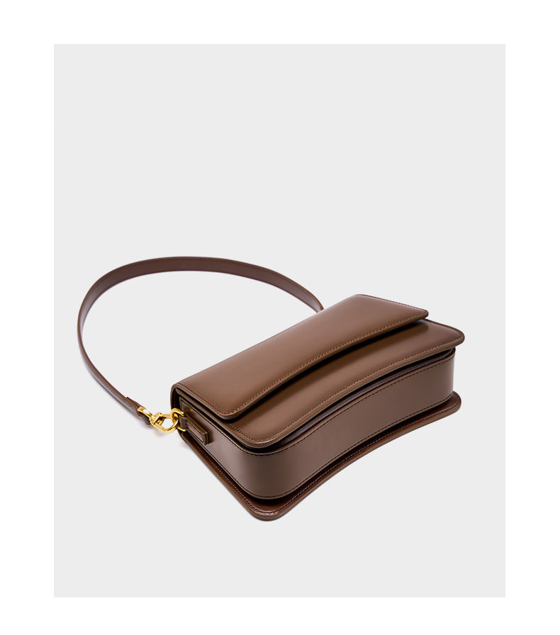 Top-down perspective of brown leather mini bag with rounded baguette silhouette