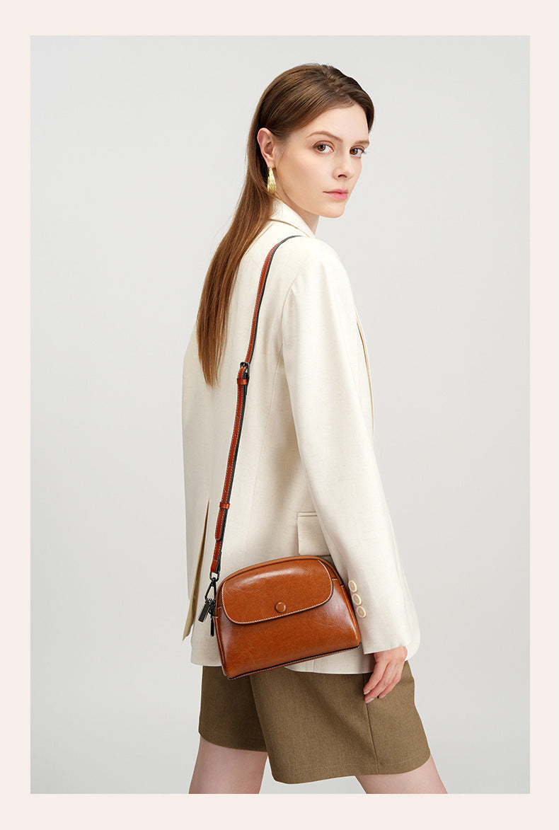Side profile of model wearing caramel leather crossbody bag