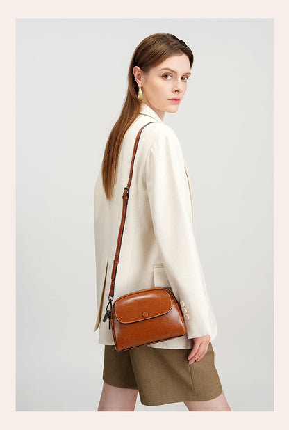 Side profile of model wearing caramel leather crossbody bag