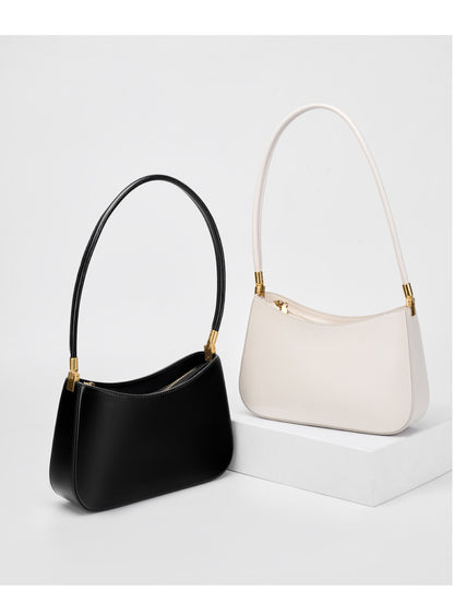 Black and cream shoulder bags displayed side by side on a white pedestal