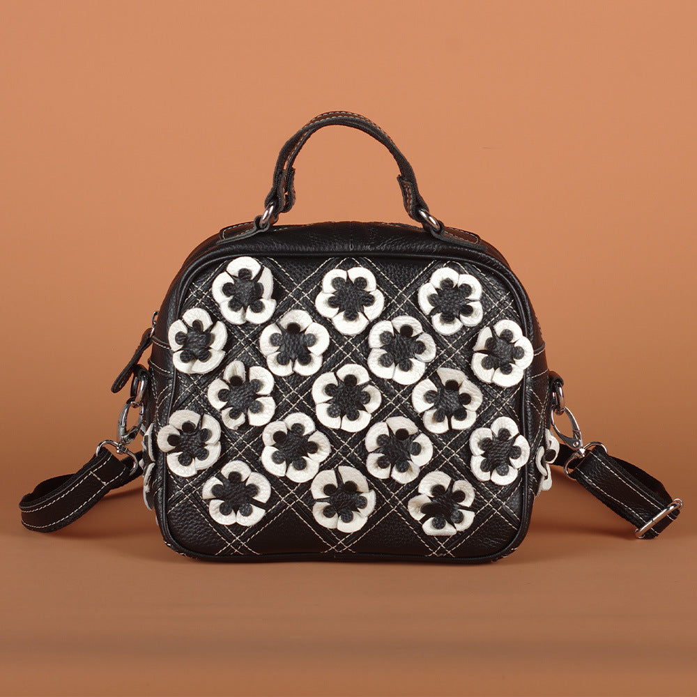 Front view of black floral bag with quilted contrast stitching