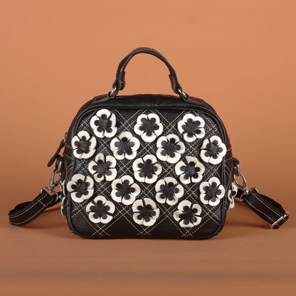 Front view of black floral bag with quilted contrast stitching