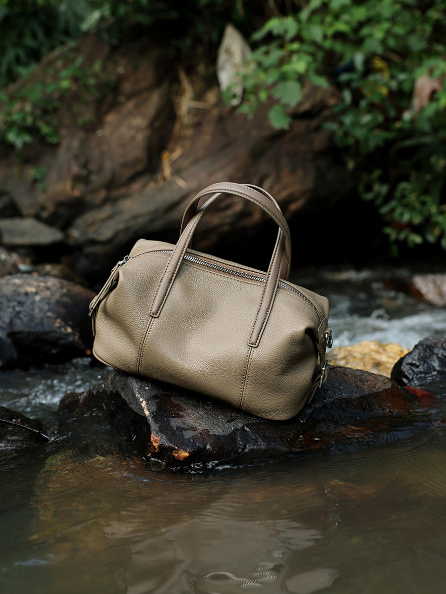 Elephant gray bag resting on a rock by a stream