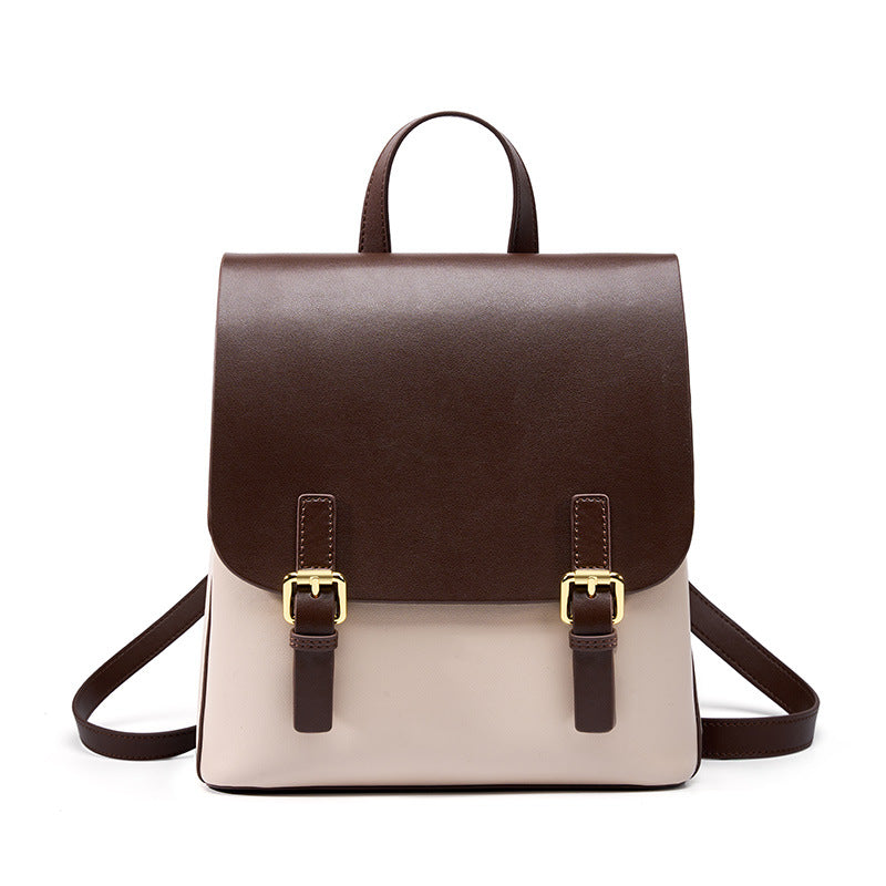 Two-tone cowhide leather backpack with dark brown flap and cream body, gold-tone buckles, front view