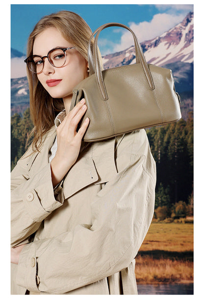 Model holding elephant gray bag near shoulder