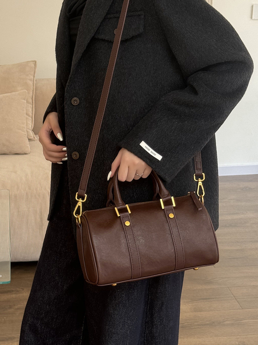Model wearing dark brown leather Boston bag crossbody with wool coat