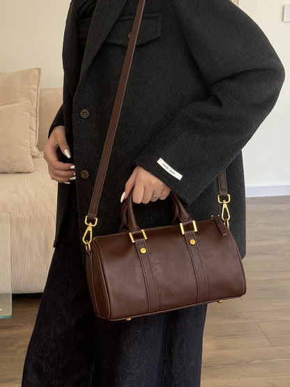 Model wearing dark brown leather Boston bag crossbody with wool coat