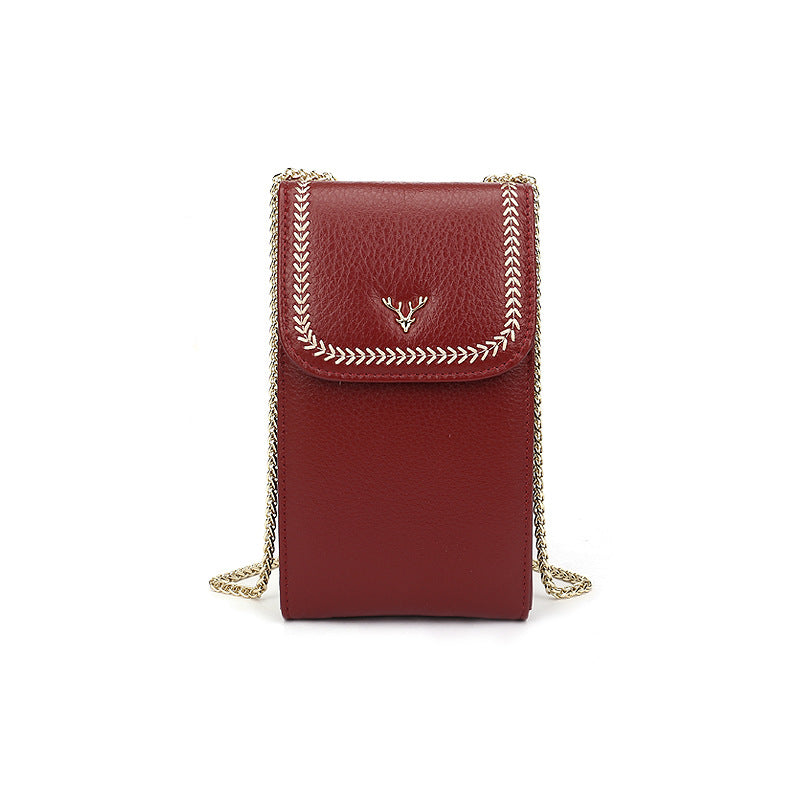 Wine red cowhide mini crossbody phone bag with chain strap and deer head accent on white background