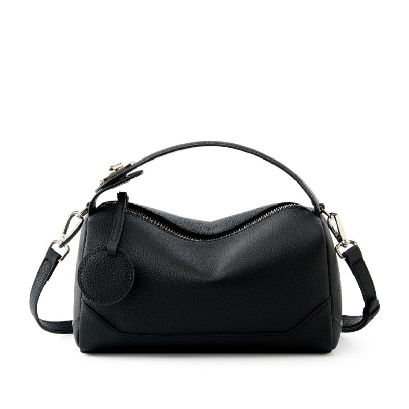 Midnight black top-grain cowhide mini Boston bag with top handle on white background