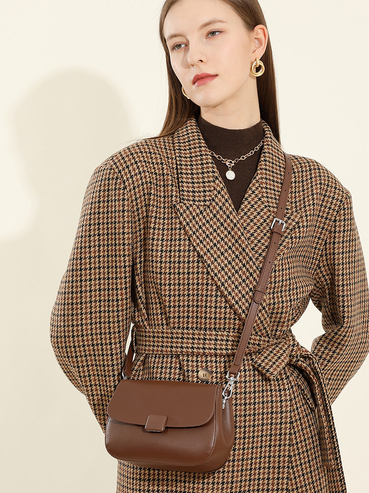 Front view of model with brown leather crossbody bag worn as shoulder bag