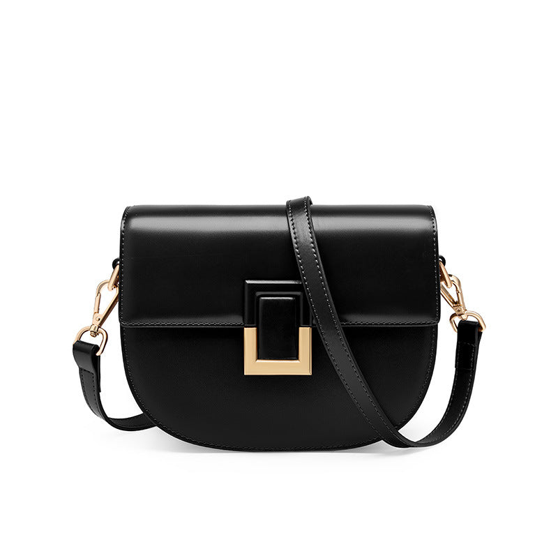 Black cowhide mini saddle crossbody bag with gold-tone turn-lock, front view