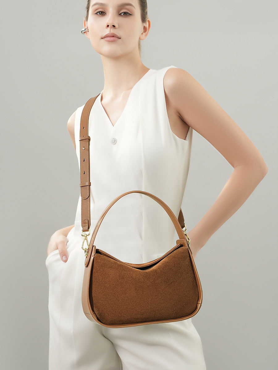 Model carrying the brown cowhide bag with its long strap