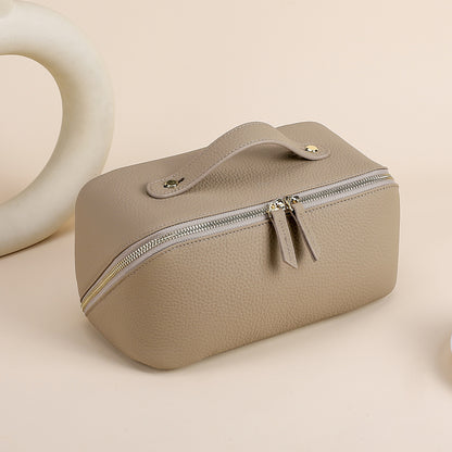 Gray leather cosmetic pouch with textured exterior and zip closure