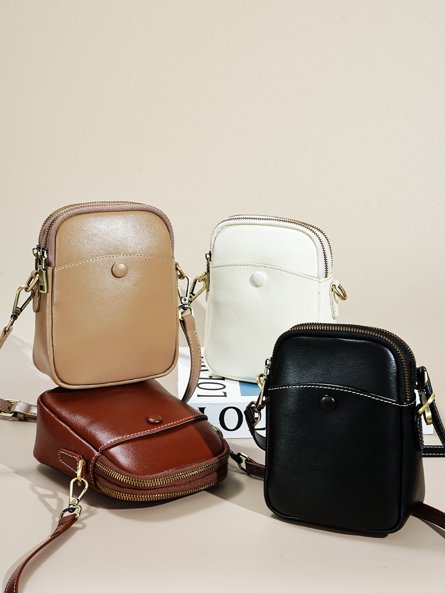 Four color cowhide leather mini crossbody bags grouped together on neutral background
