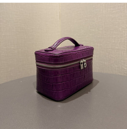 Front view of a purple pouch with a top handle and double zipper pulls