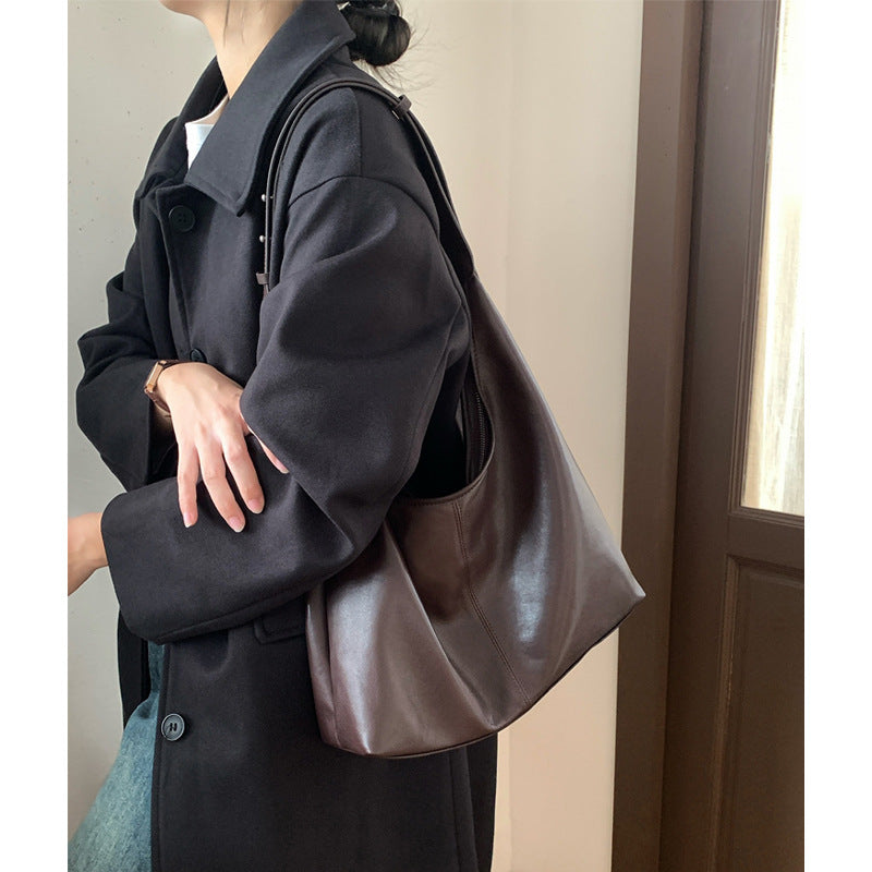 Side view of the soft brown hobo tote worn over a coat