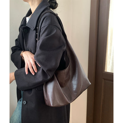Side view of the soft brown hobo tote worn over a coat