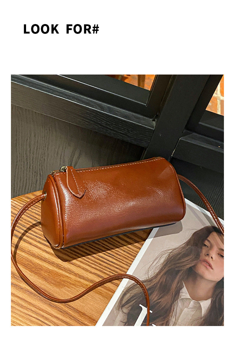 Caramel brown cowhide barrel bag detail with zip pull