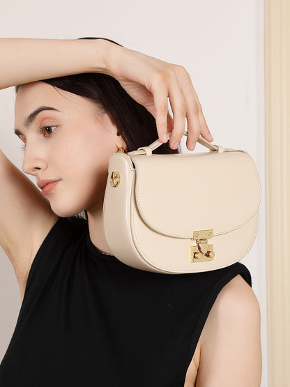 Model holding cream saddle bag by the top handle